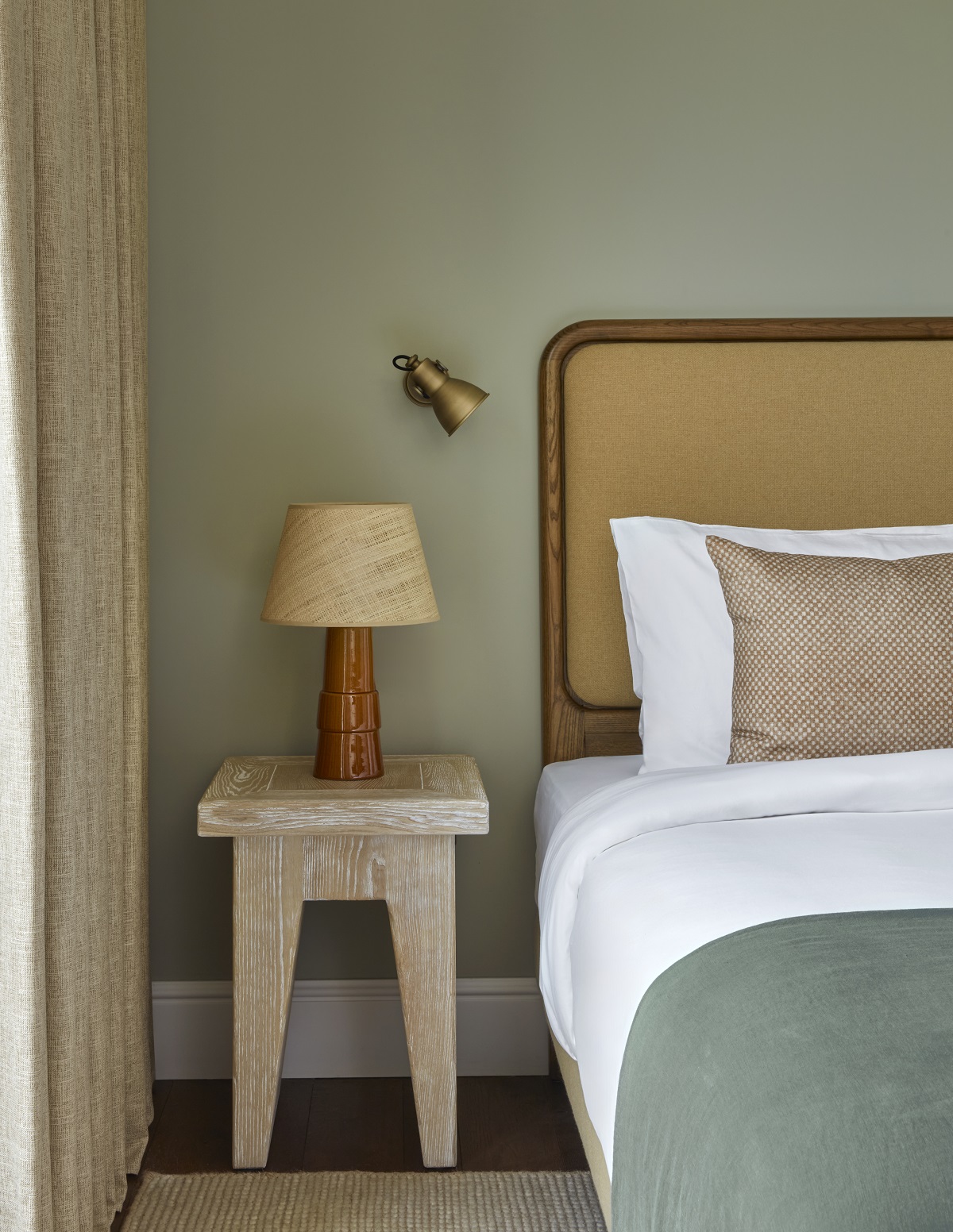 Wicker, wood and olive green details in the guest room