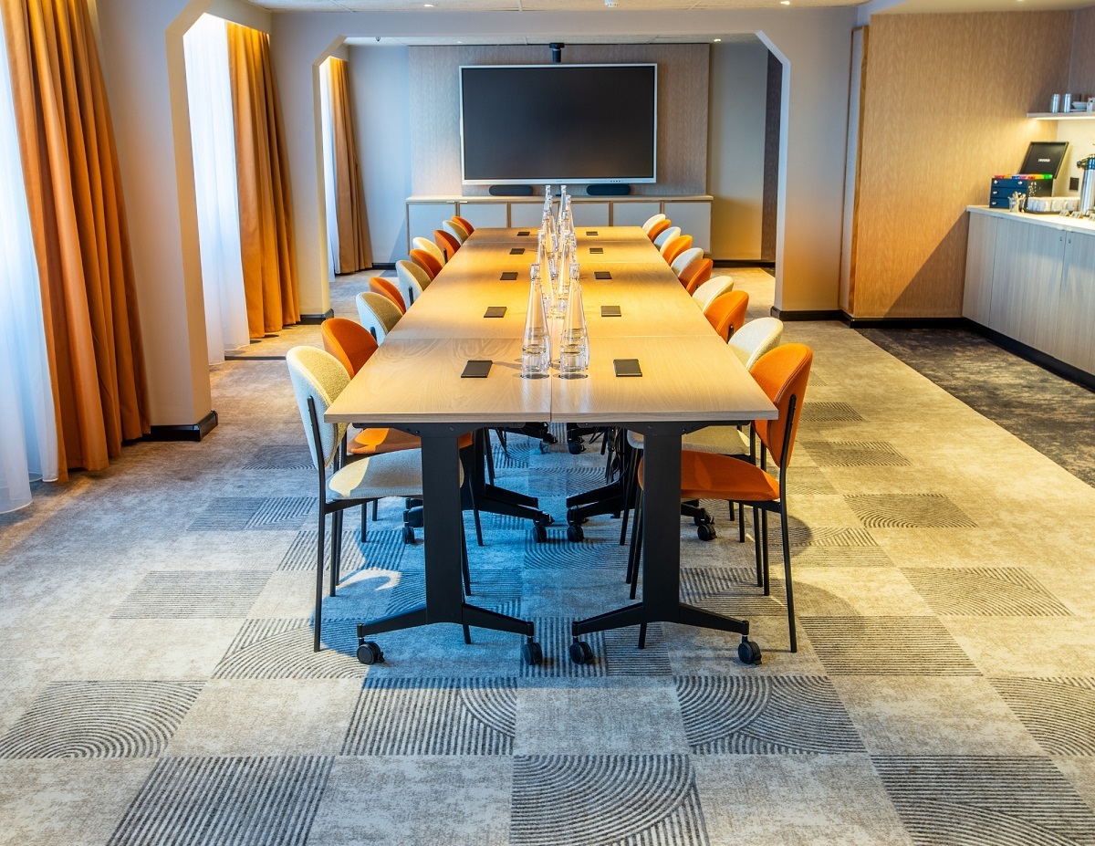 hotel meeting room with central table on grey checked carpet