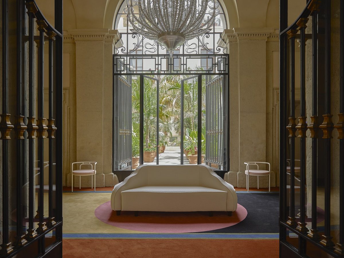 entrance to Palazzo Talìa with bold geometric carpet and couch framed by window arch