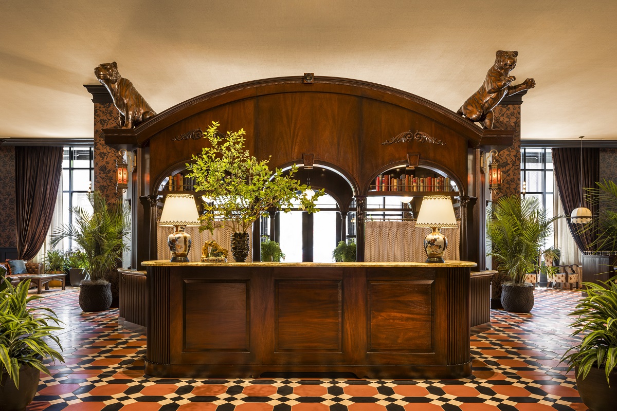 wooden carved reception desk with carved mascot leopards and tiled floor in orange and black