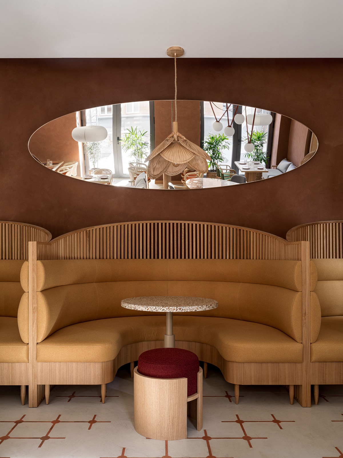 curved light wood seating booth, terracotta wall and terrazzo table