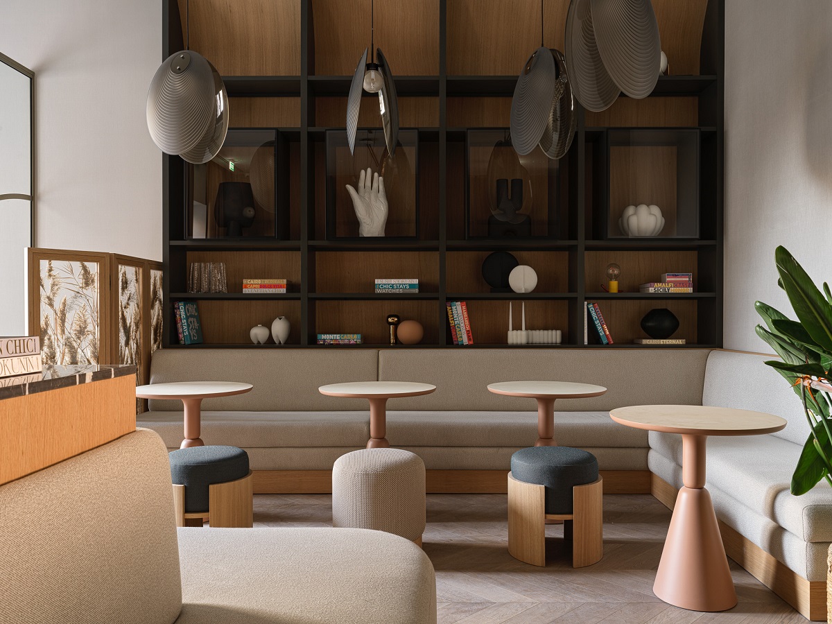 dark blue and wood library wall in hotel lobby with light wood tables and seating