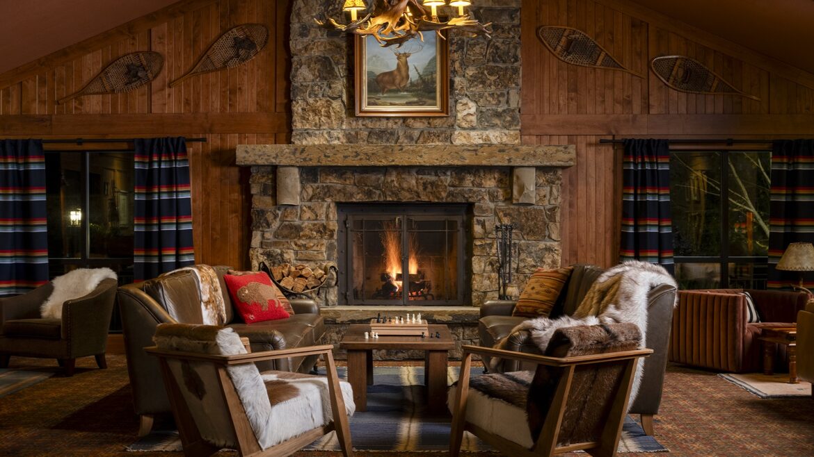 stone fireplace and wooden chairs in rustic Wayfinder hotel