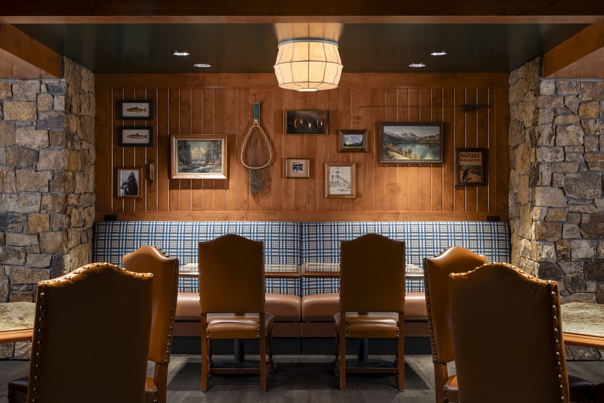 wood and stone surfaces, checked banquette and leather chairs in rustic hotel restaurant