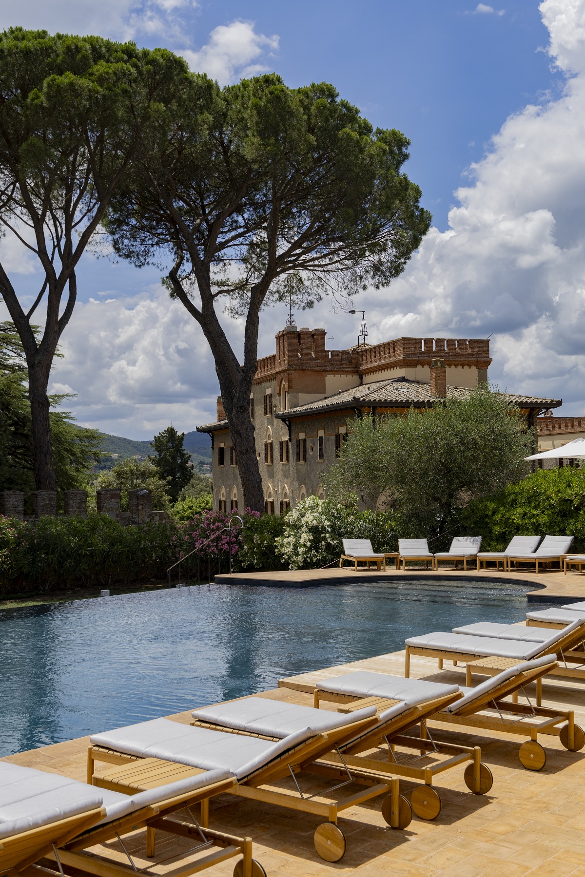 swimming pool with sunloungers with hotel in background