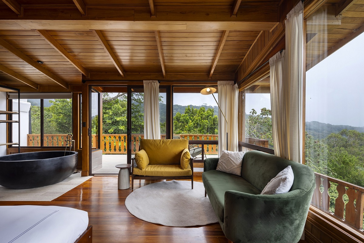 chairs and freestanding bath opening onto wooden deck over forest