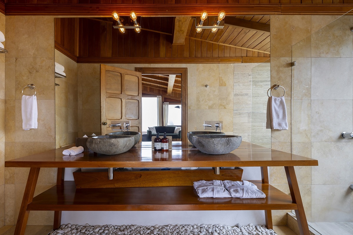 wooden bathroom vanity with natural stone basin in hotel belmar