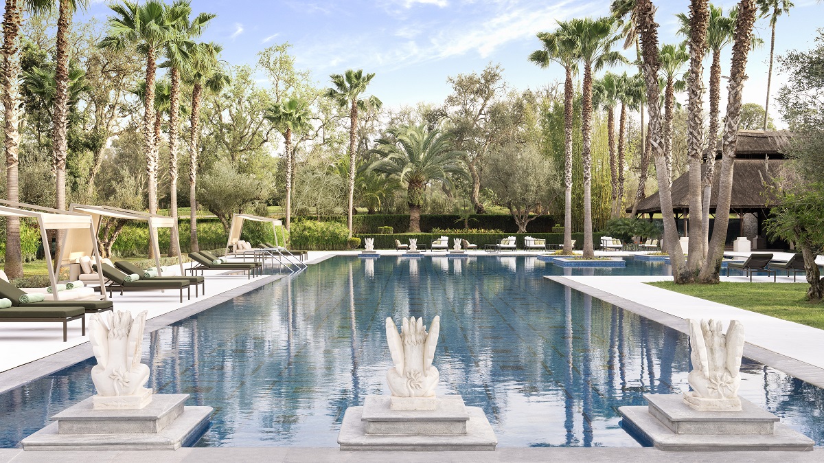 outdoor pool flanked by palm trees in morocco