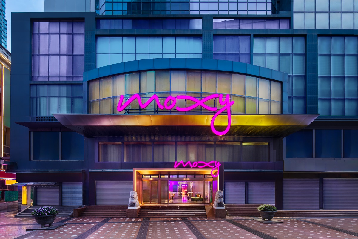 pink neon lettering above entrance to Moxy hotel