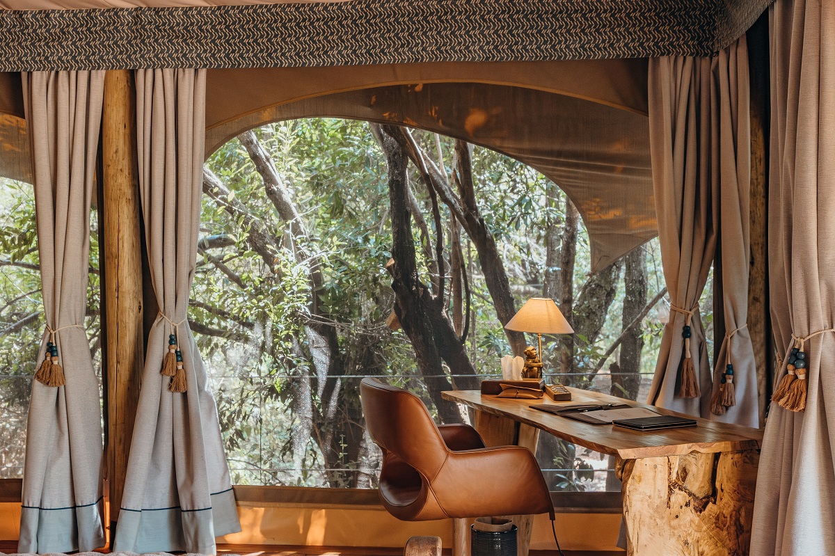 leather chair and wooden desk in tent in the trees at Mara Toto Camp