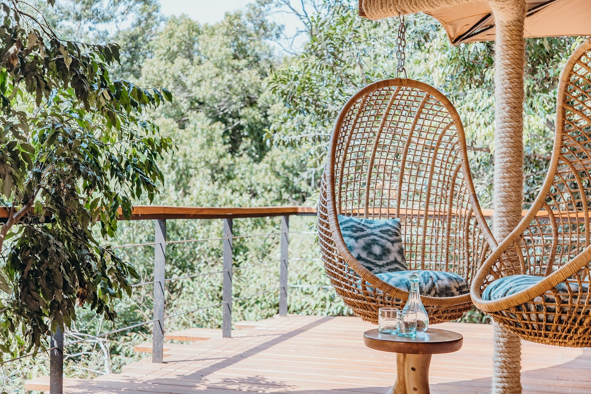 hanging weaver bird nest chairs on deck in treetop camp