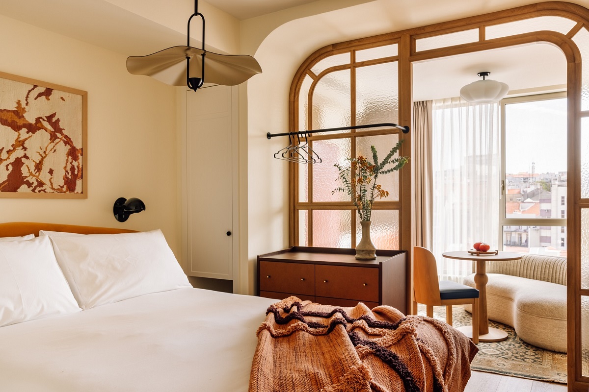 Lisbon Locke hotel guestroom with terracota woven bedthrow and art on the wall by Ana Teresa Barboza