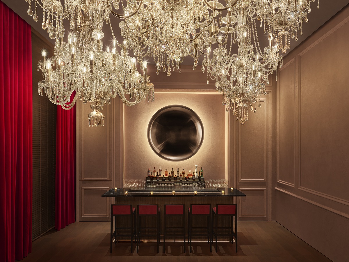 private bar in singapore with chandeliers and red curtains