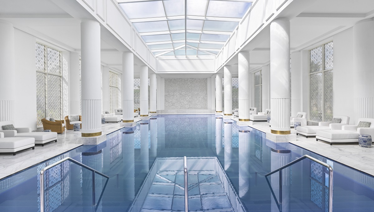 white interior pool and wellness area with white pillars and white daybeds