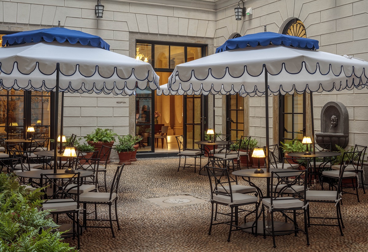 central courtyard with tables, chairs and blue and white parasols