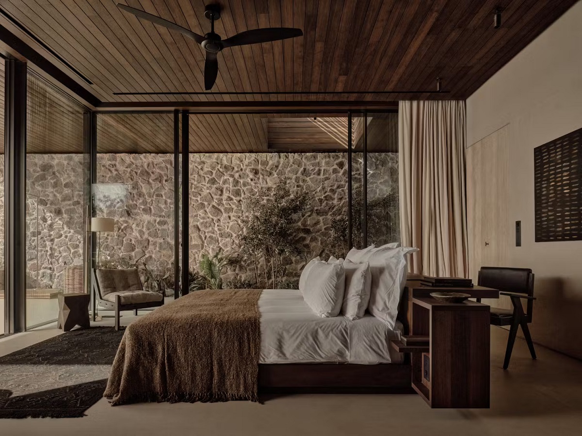 bedroom with glass doors on 2 sides and wooden ceiling with fan