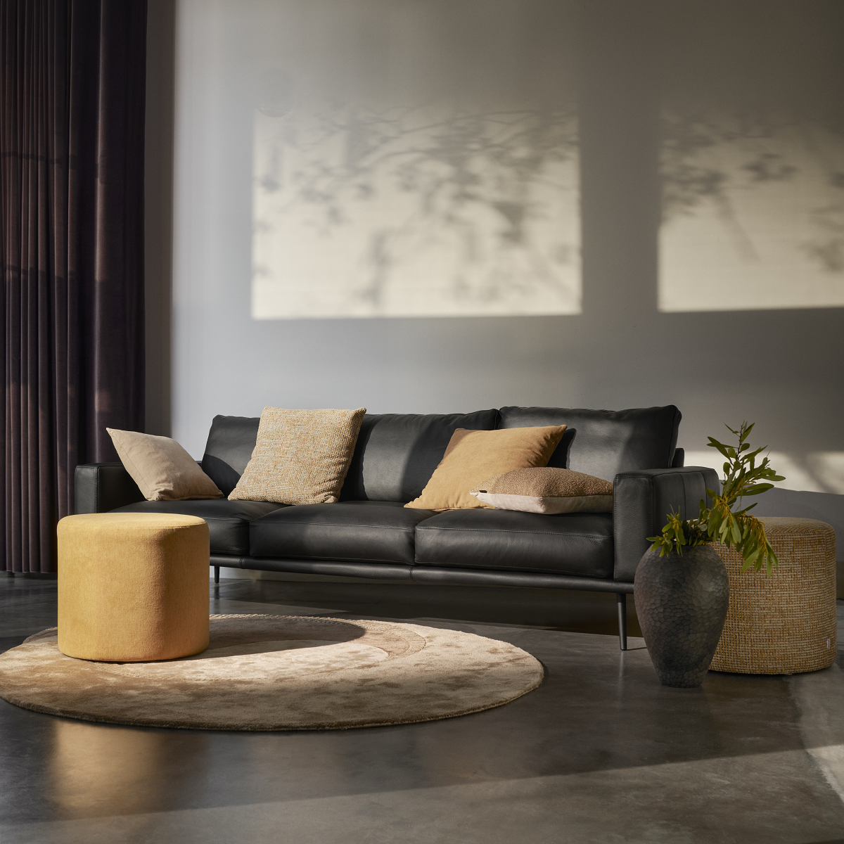 black BoConcept couch against grey wall with shadows