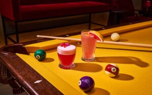 pink cocktails on a bright yellow pool table at Wonder Room Singapore