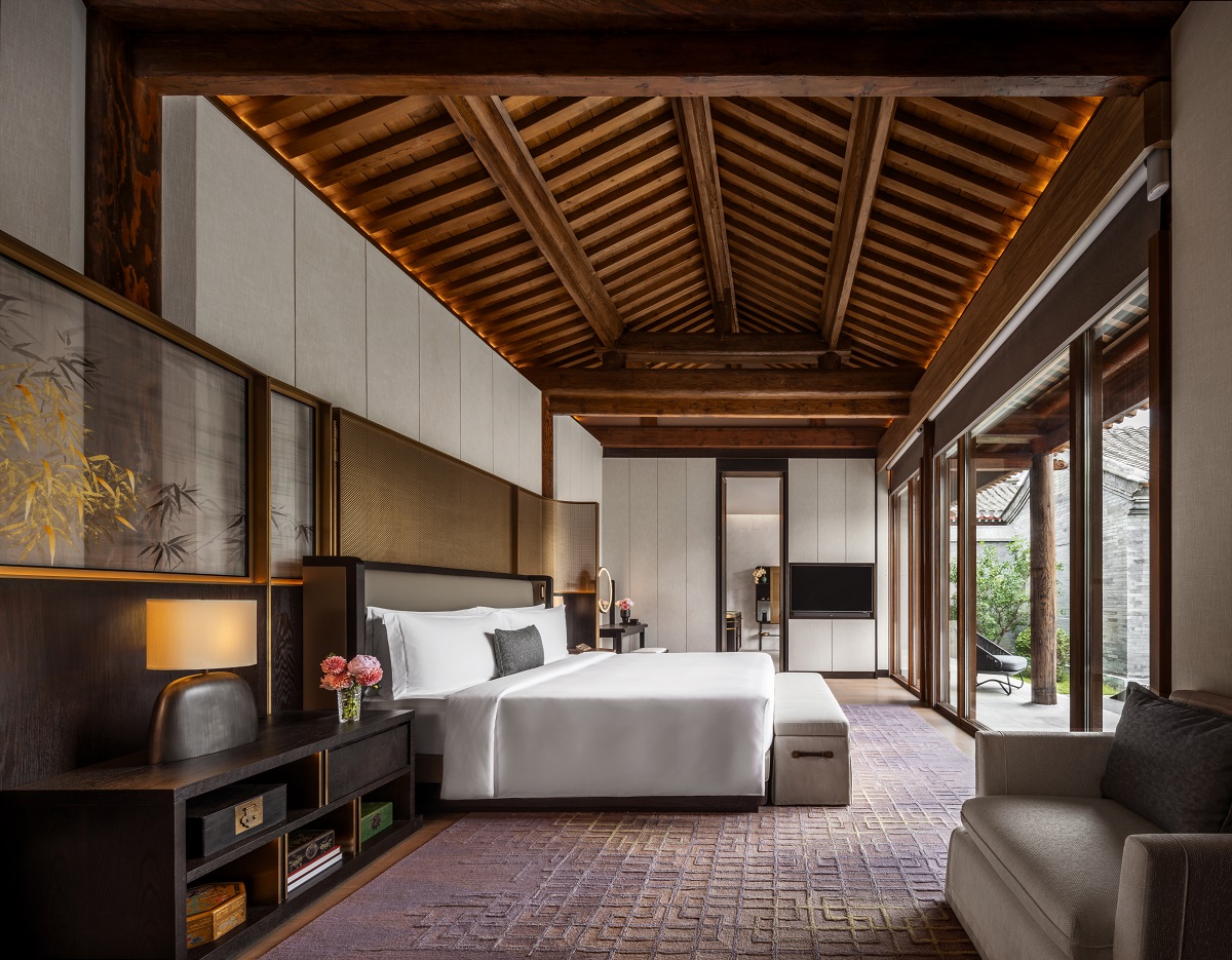 guestroom with bed under pitched wooden roof in Qianmen courtyard peking mansion