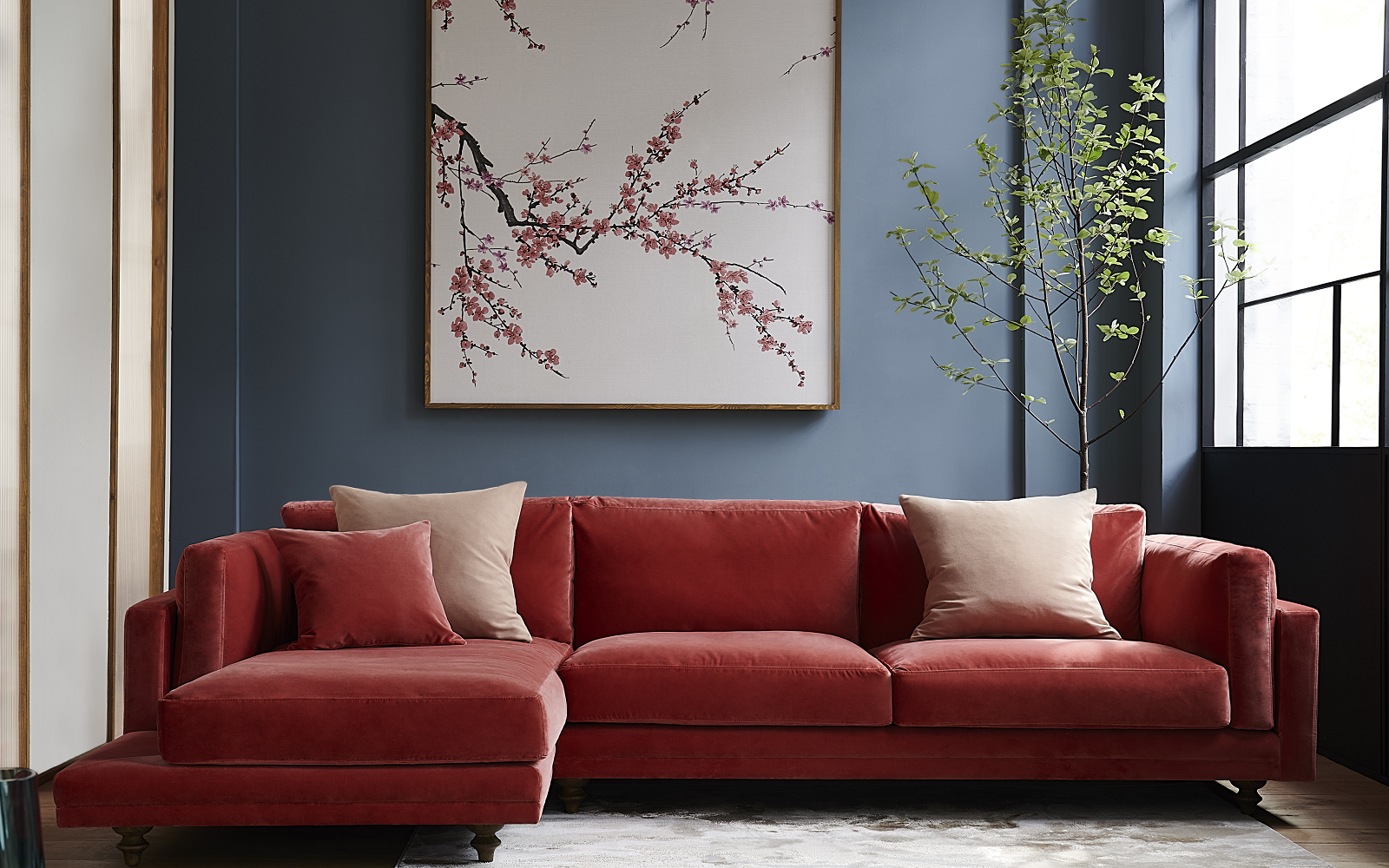 rose pink corner sofa against grey wall