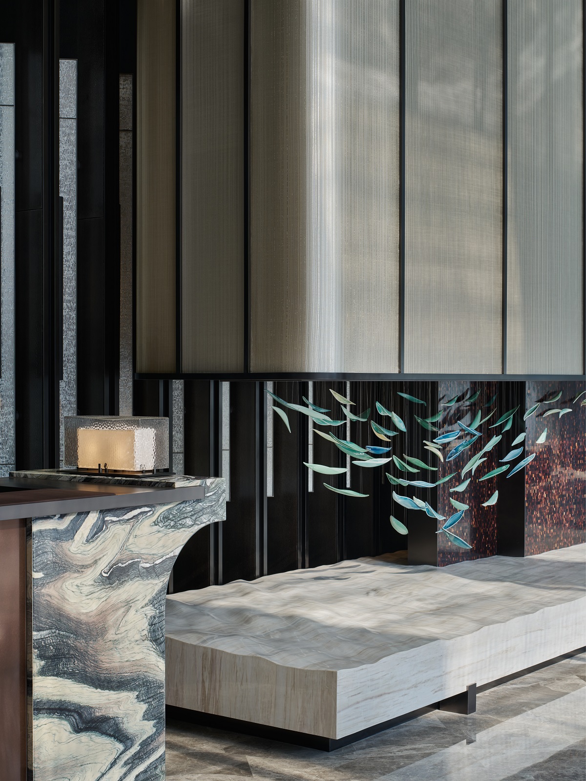 marble reception area next to textured stone surface and ceramic leaves installation