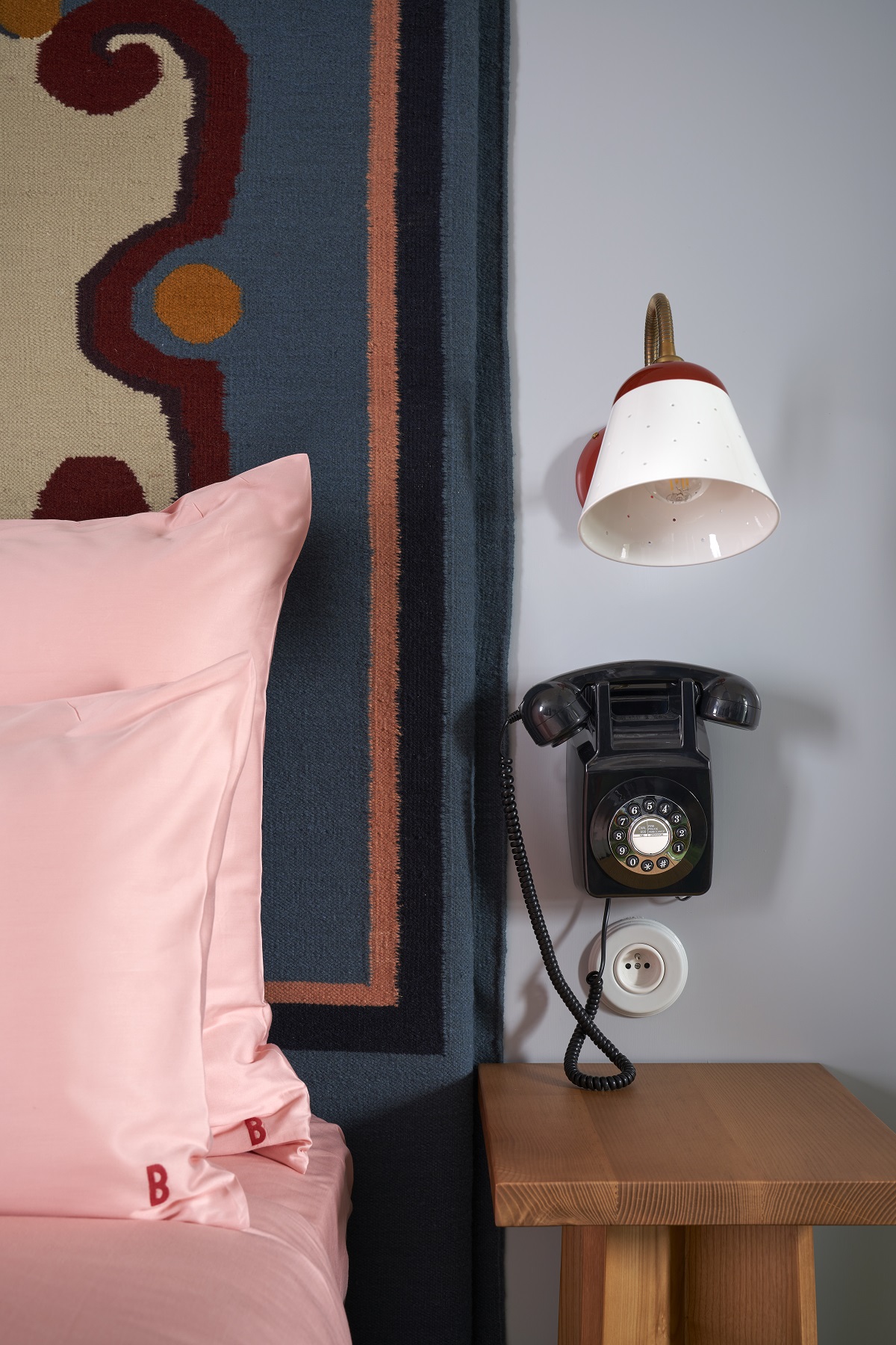 vintage phone and details next to bed with pink linen