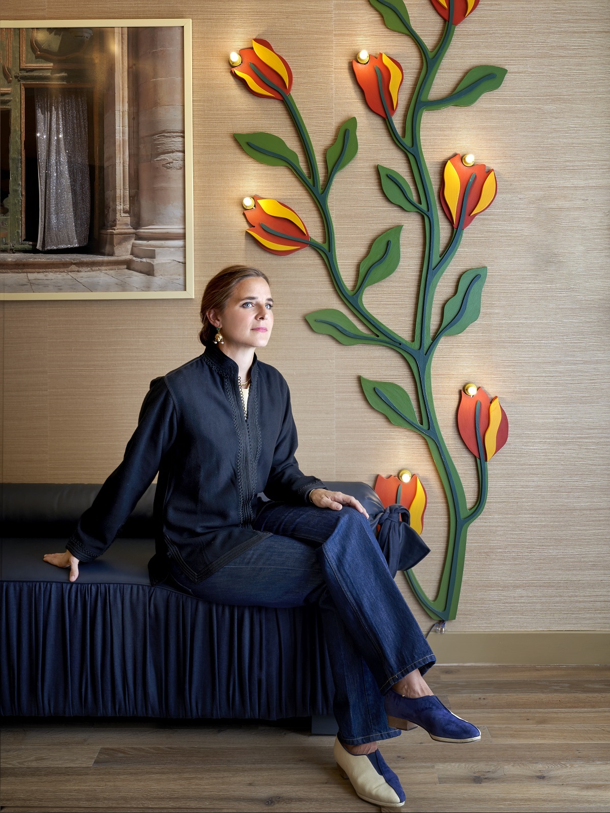 designer, Beata Heuman on blue couch in Hotel de la Boetie