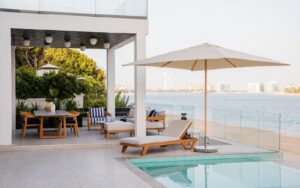 white deck on the beach with wood and white umbrella and furniture