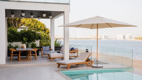 white deck on the beach with wood and white umbrella and furniture