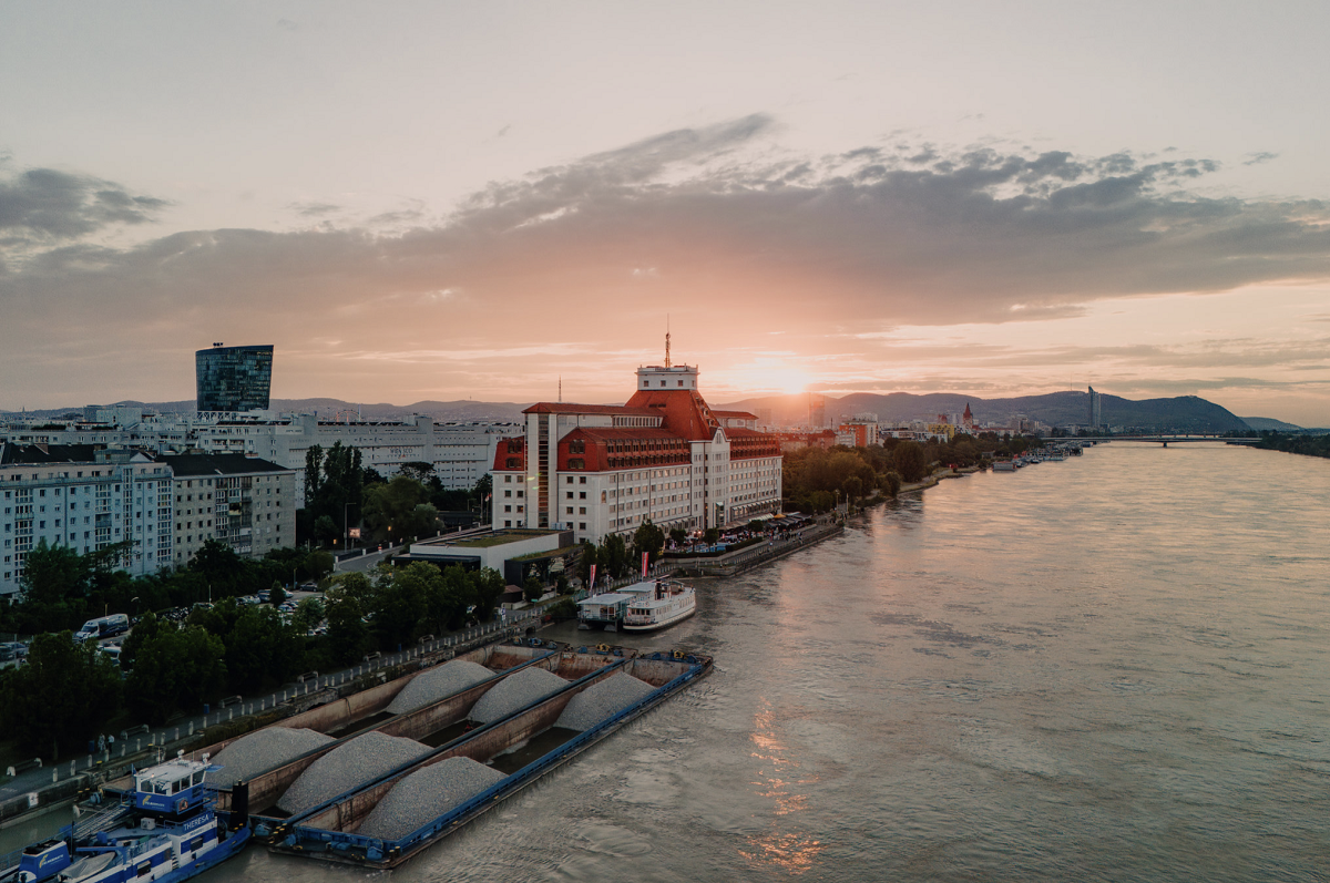 exterior view of Hilton Vienna waterfront with river at sunset