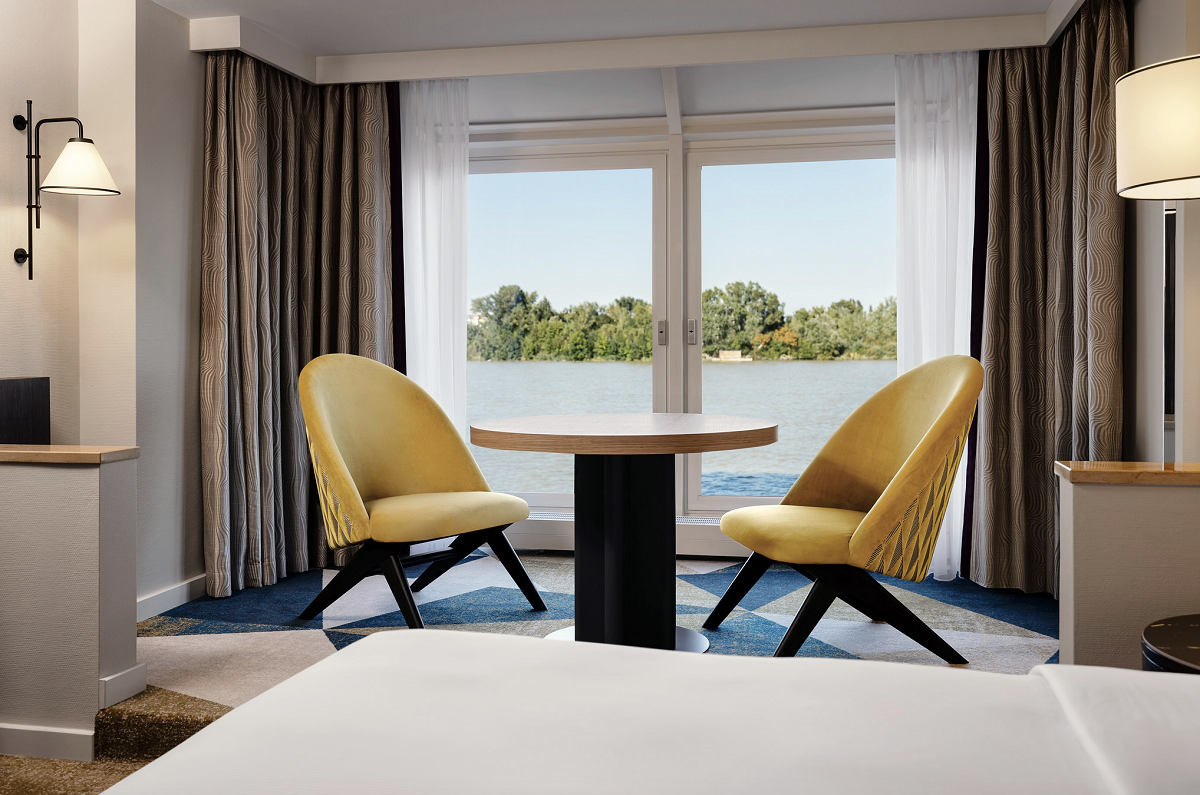 table and chairs in guestroom with view on to Danube river