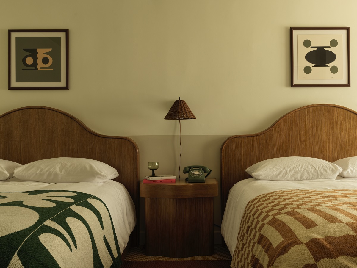 curved wooden bedheads and patterened woven throws in the guestroom at Casa Loma