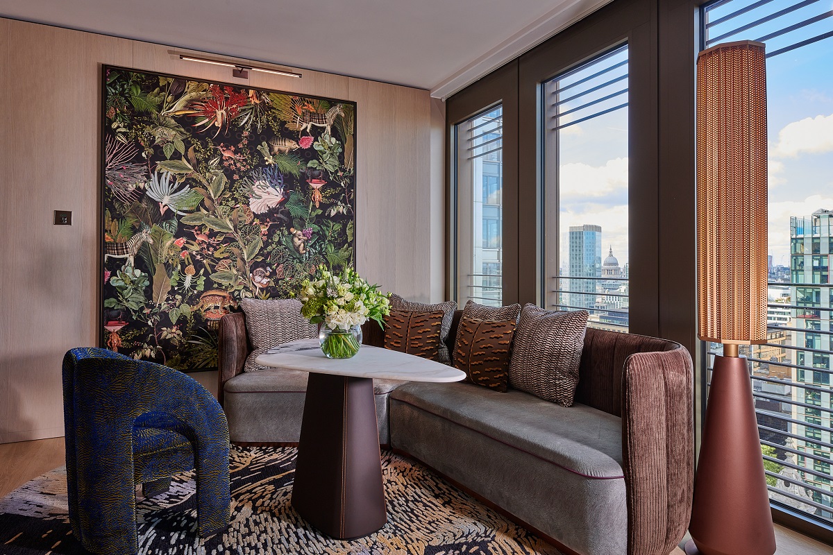 chair and couch in suite at Pan Pacific London with tropical wall decoration