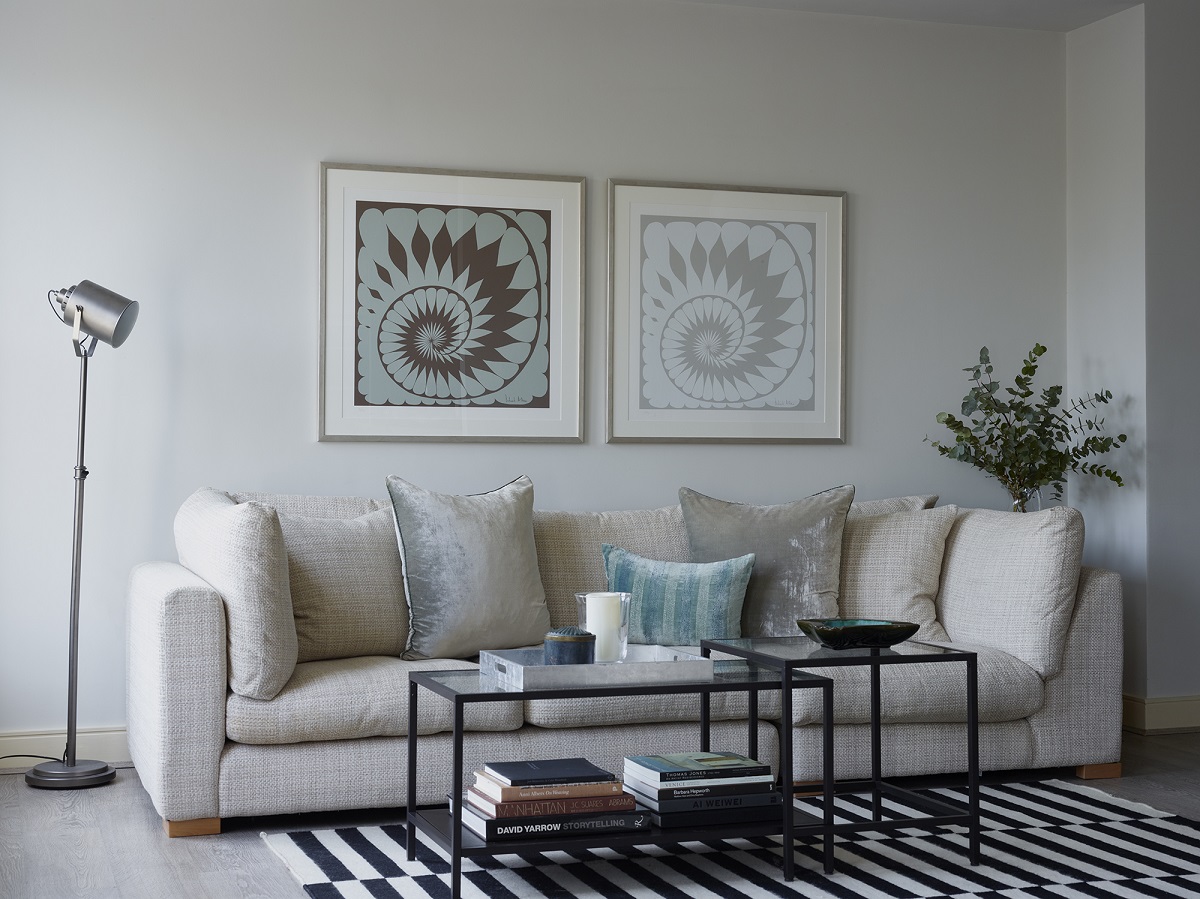 framed Richard Allan scarves on wall above cream sofa