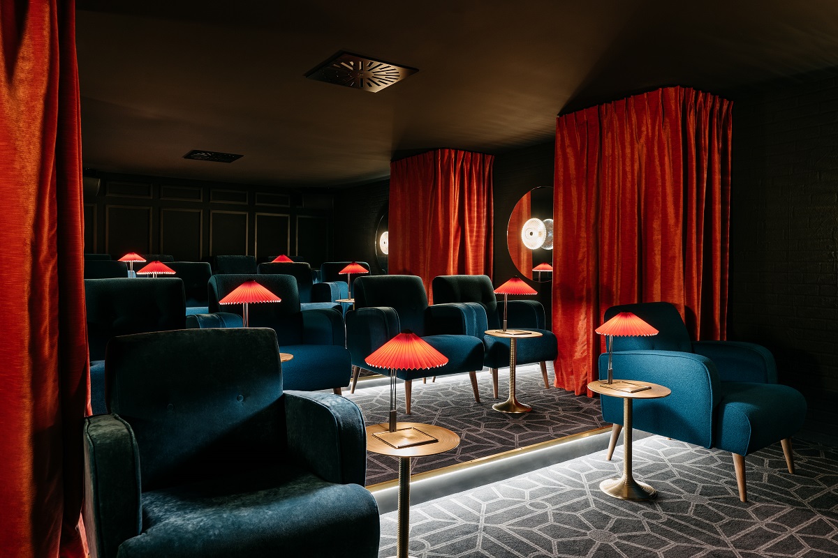 blue chairs, red velvet curtains and table lamps in vintage cinema