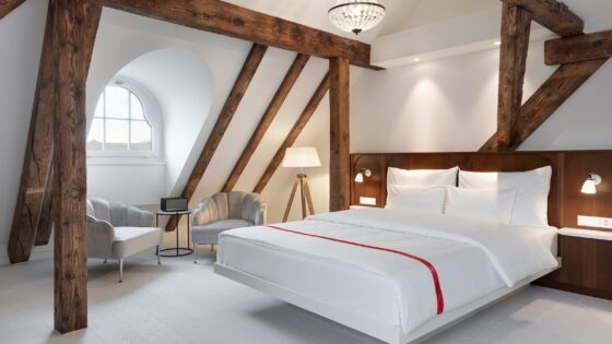 loft guestroom in Ruby Mimi Zurich with exposed wooden beams above the bed