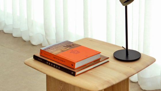 wooden side table from Ligne Roset Contract with lamp and books