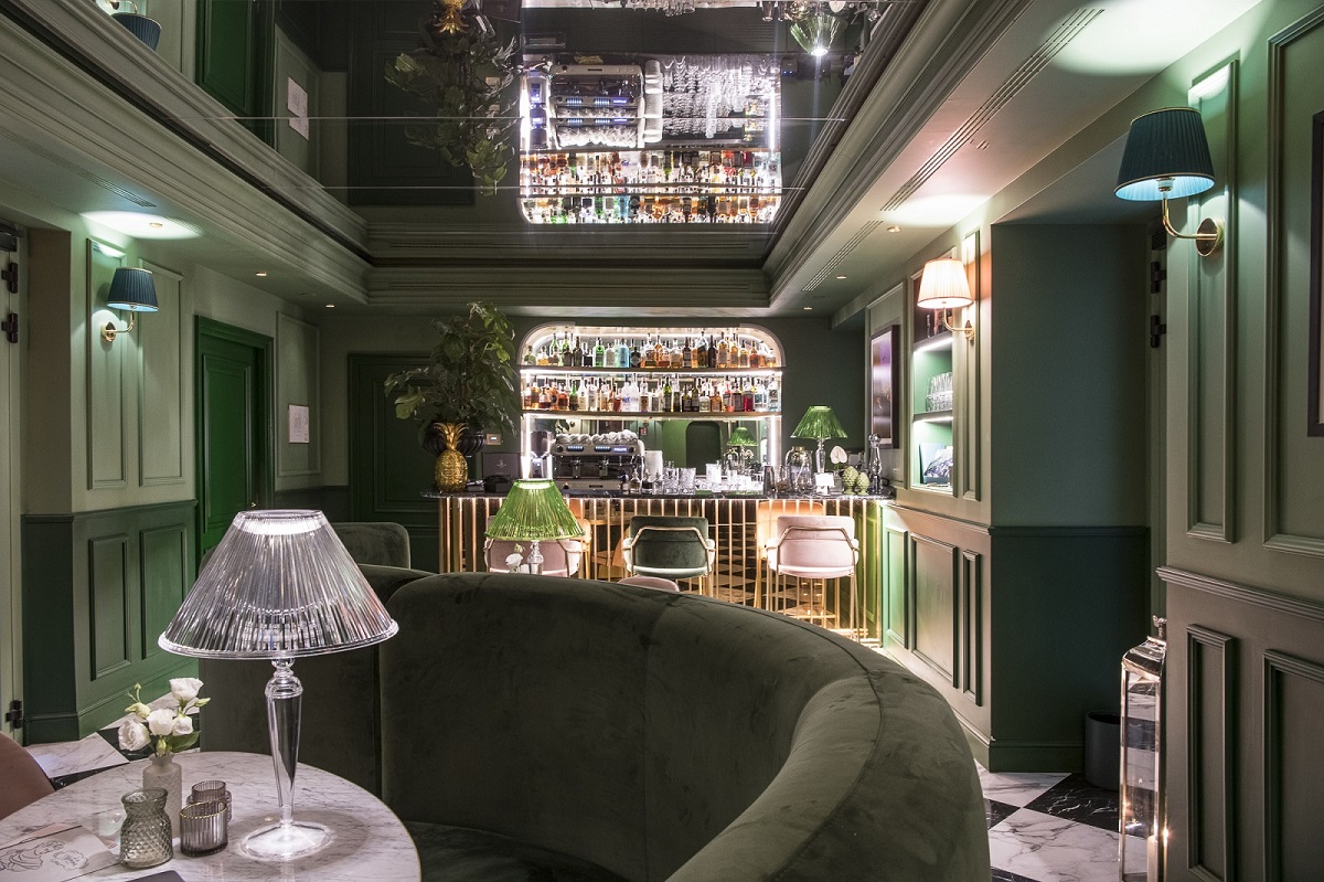 curved green banquette, green walls with backlit bar