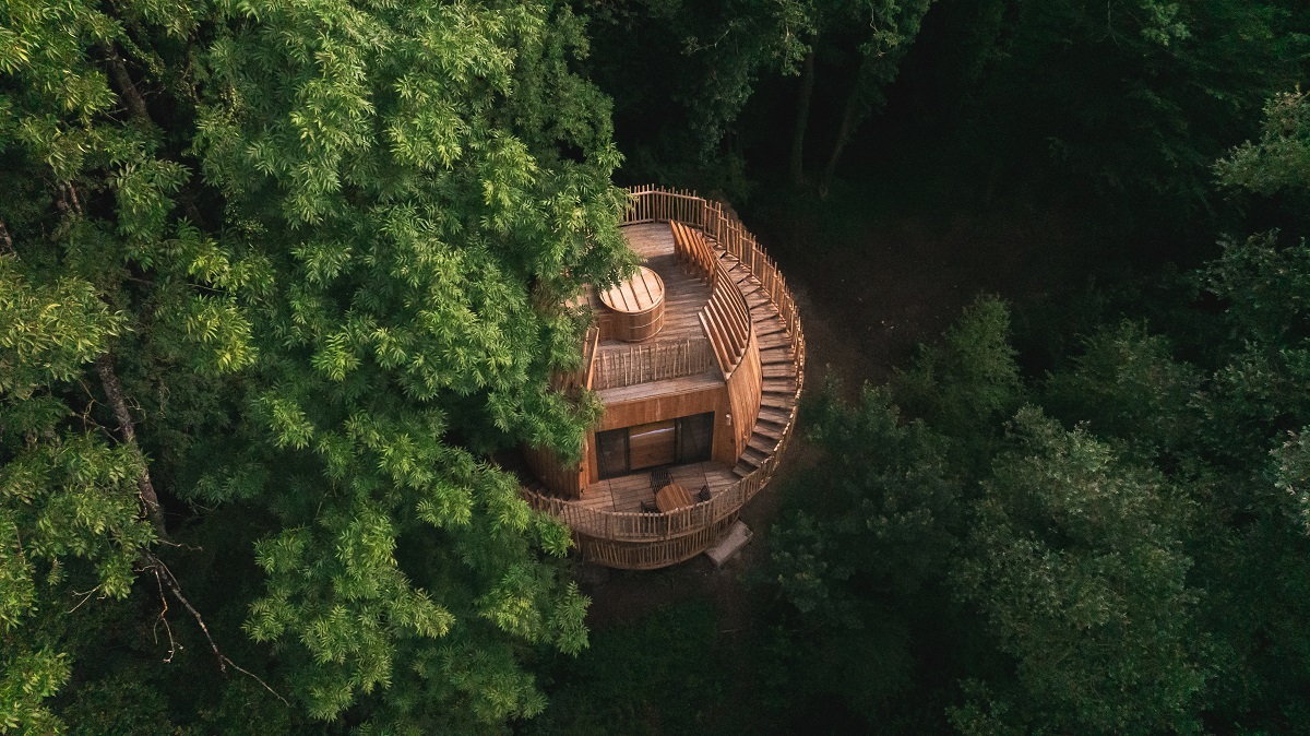 tree canopy surrounding wooden treehouse cabin by Coucoo Cabanes