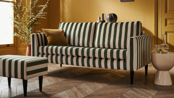 Lounge area with green stripe sofa and footstool with mustard walls, from sofa.com