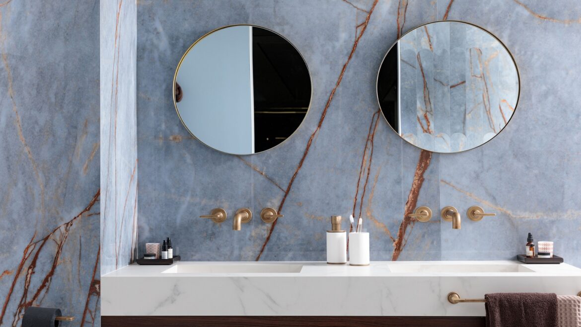 two round mirrors above double vanity in marble bathroom