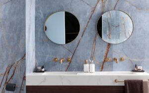 two round mirrors above double vanity in marble bathroom