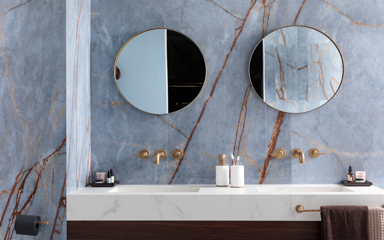 two round mirrors above double vanity in marble bathroom