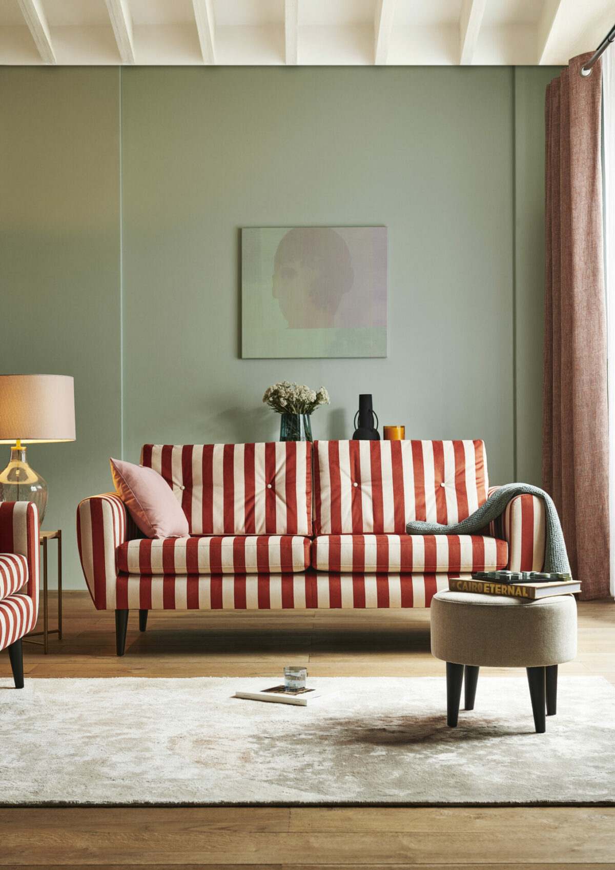 3 Seater Sofa and Armchair in Orange Stripe, set against a pale sage wall with wood floor and cream accents