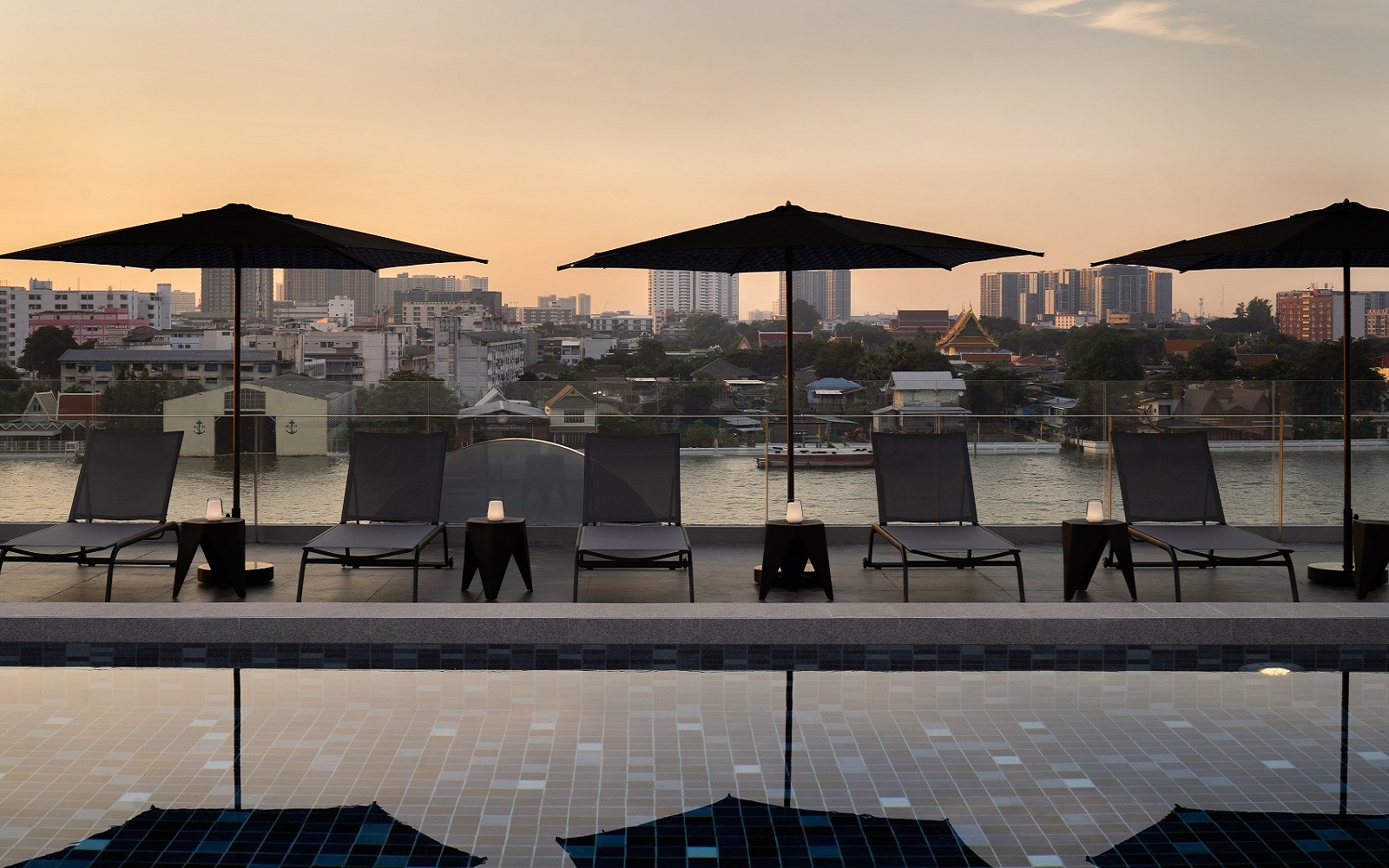 pool and parasols at dusk at The StandardX, Bangkok Phra Arthit