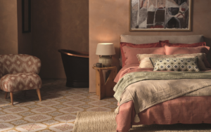 bedroom with layered textiles on bed and patterned tiles from Hyperion on the floor