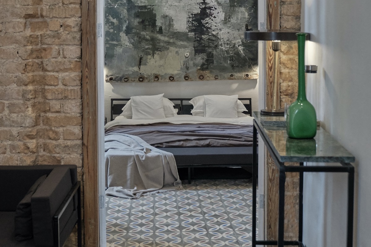 view into guestroom with large abstract painting above the bed