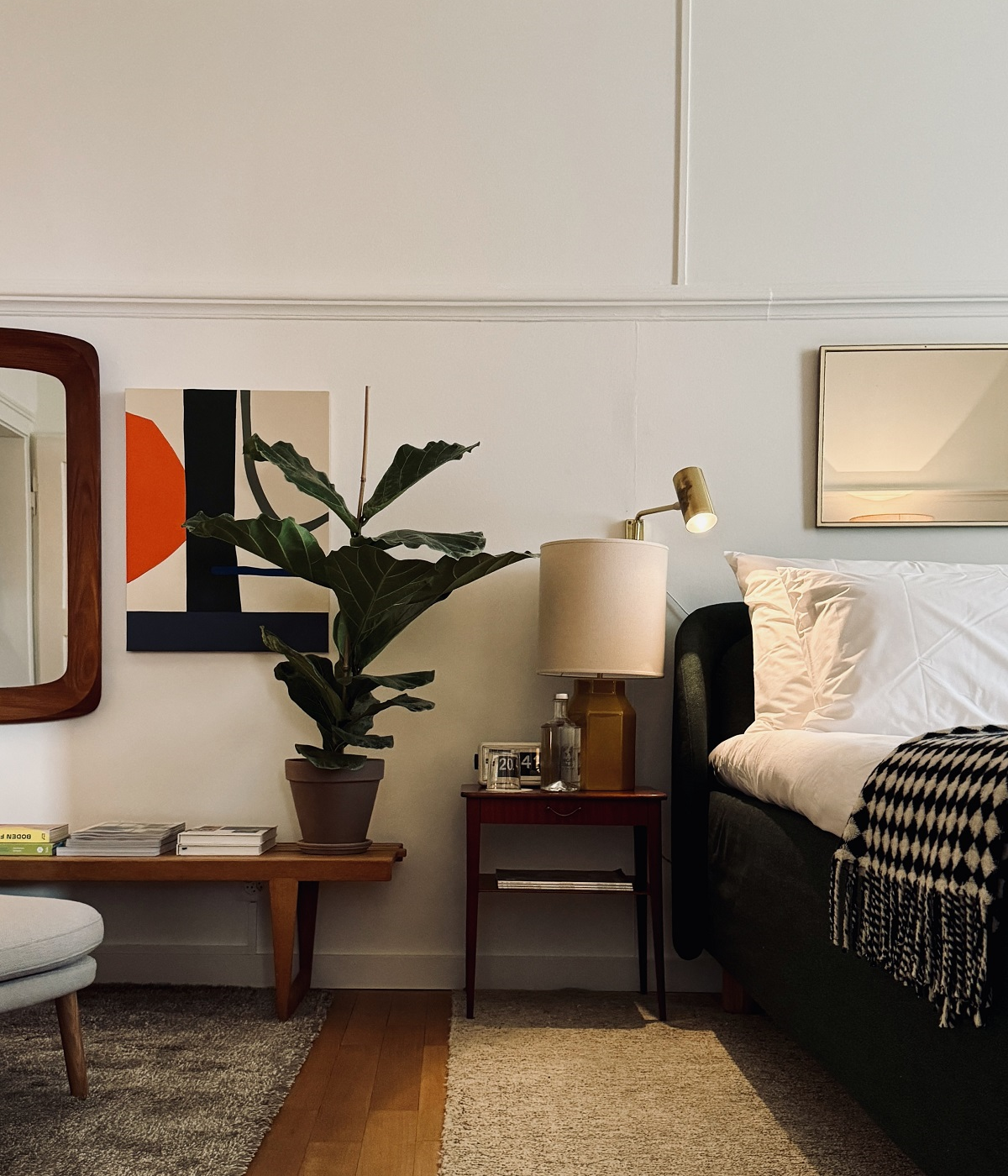 bedroom detail with plant and art next to the bed in OXEN