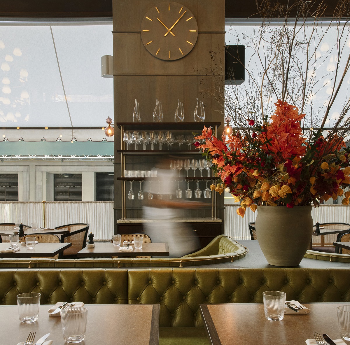 floral arrangement on bar with view across tables to streetside windows