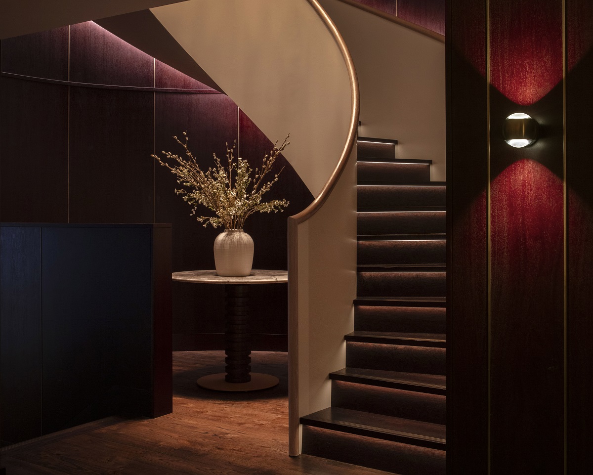 staircase with recessed lighting leading guests into dining room